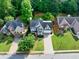 Aerial view of a suburban home with manicured lawns, surrounded by mature trees and neighborhood houses at 4174 Chatham Crest Ln, Buford, GA 30518