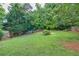 Expansive backyard featuring a well-maintained lawn and a surrounding wooded area, with a partial fence view at 4174 Chatham Crest Ln, Buford, GA 30518