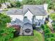 Aerial view of a home's backyard featuring a covered patio, lush landscaping, and a well-maintained lawn at 4174 Chatham Crest Ln, Buford, GA 30518
