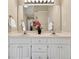 Bathroom featuring double sinks with white cabinetry, a large mirror, and bright lighting at 4174 Chatham Crest Ln, Buford, GA 30518
