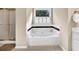 Bright bathroom showcasing a soaking tub beneath a window for a relaxing and luminous space at 4174 Chatham Crest Ln, Buford, GA 30518