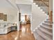 Inviting entryway with hardwood floors, a staircase, and a view into the living room at 4174 Chatham Crest Ln, Buford, GA 30518