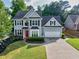 Beautiful two-story home with a well-manicured lawn, lovely landscaping, and a driveway leading to a garage at 4174 Chatham Crest Ln, Buford, GA 30518