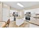 Bright kitchen features white cabinets, stainless steel appliances, and a center island at 4174 Chatham Crest Ln, Buford, GA 30518