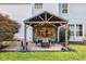 Covered patio with dining table and seating, overlooking the backyard and nearby house windows at 4174 Chatham Crest Ln, Buford, GA 30518