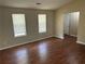 Cozy bedroom with two windows, neutral walls, dark wood-look floors, and a closet door at 6536 Rebecca Lou Ln, Lithonia, GA 30058