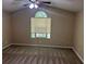 Bedroom featuring carpeted floors, neutral walls, and a large window at 6536 Rebecca Lou Ln, Lithonia, GA 30058