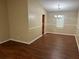 Dining room showcasing a modern chandelier, wood-look floors, and large wall trimmed in wainscoting at 6536 Rebecca Lou Ln, Lithonia, GA 30058