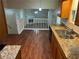 Open kitchen featuring granite countertops, stainless steel sink, and wood-look floors at 6536 Rebecca Lou Ln, Lithonia, GA 30058
