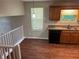 Kitchen with stainless steel sink, wood cabinets, and wood-look flooring, with an adjacent staircase at 6536 Rebecca Lou Ln, Lithonia, GA 30058