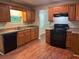 Kitchen with wood cabinets, dark appliances, granite countertops, and wood-look flooring at 6536 Rebecca Lou Ln, Lithonia, GA 30058