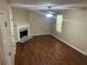 Living room with a cozy fireplace, wood-look floors, and a ceiling fan at 6536 Rebecca Lou Ln, Lithonia, GA 30058