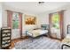 Sunlit bedroom featuring hardwood floors, matching twin beds and colorful decorative wallpaper at 1682 Grace Se St, Atlanta, GA 30316