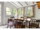 Sunlit dining area featuring a large wooden table with seating for eight, surrounded by windows with tree views at 1682 Grace Se St, Atlanta, GA 30316