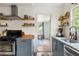 Contemporary kitchen featuring granite countertops, floating shelves, and stainless steel appliances with adjacent room view at 1682 Grace Se St, Atlanta, GA 30316