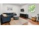 Bright living room with a blue sectional sofa, modern coffee table, and a window view at 1682 Grace Se St, Atlanta, GA 30316