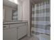 Bright bathroom with a gray countertop and gray and white striped shower curtain at 204 Mahnaz Dr, Atlanta, GA 30331