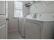 Bright laundry room featuring a window, washer, dryer, and shelving at 204 Mahnaz Dr, Atlanta, GA 30331