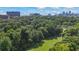 An aerial view shows dense tree coverage and a small green field with the city skyline in the background at 291 Goodson Nw Way, Atlanta, GA 30309