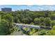 An aerial shows a train crossing a bridge in a neighborhood with dense tree coverage, and the city skyline in the background at 291 Goodson Nw Way, Atlanta, GA 30309