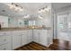 Bathroom vanity with double sinks, white cabinets, and wood-look floors at 291 Goodson Nw Way, Atlanta, GA 30309