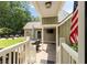 Covered back porch with stone tile, a mounted television, and an American flag at 4530 Upland Court, Cumming, GA 30040