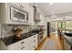 Elegant kitchen showcasing stone backsplash, stainless steel appliances, and black countertops at 4530 Upland Court, Cumming, GA 30040