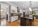 Well-lit kitchen featuring stone backsplash, island seating, stainless appliances, and open layout at 4530 Upland Court, Cumming, GA 30040