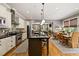 Modern kitchen boasts stainless steel appliances, island with seating, and seamless flow to dining area at 4530 Upland Court, Cumming, GA 30040