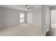 Bedroom featuring neutral carpet, a ceiling fan, double closet, and a bright window at 5040 Meadow Lane Ne, Marietta, GA 30068