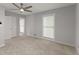 Spacious bedroom featuring neutral carpet, a ceiling fan, double closet, and bright window at 5040 Meadow Lane Ne, Marietta, GA 30068