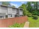 Attractive gray townhome showcasing a privacy fence, green lawn, and mature trees at 5040 Meadow Lane Ne, Marietta, GA 30068