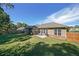 Lush backyard with a large grassy area, mature trees, and a patio seating area at 686 Stark St, Lawrenceville, GA 30046