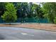 A community tennis court is fenced and surrounded by mature trees at 130 26Th Nw St # 701, Atlanta, GA 30309