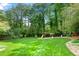 Backyard featuring a large lawn, mature trees, and a playset at 1533 High Haven Ne Ct, Atlanta, GA 30329