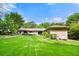 Expansive backyard featuring a lush lawn, mature trees, and a brick patio with outdoor seating, perfect for entertaining at 1533 High Haven Ne Ct, Atlanta, GA 30329