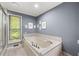 Well-lit bathroom featuring a soaking tub and a window with natural light at 1533 High Haven Ne Ct, Atlanta, GA 30329