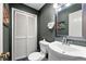 Charming powder room featuring a pedestal sink, decorative mirror, and unique artwork at 1533 High Haven Ne Ct, Atlanta, GA 30329