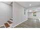 Finished basement entryway showcasing sleek gray floors, recessed lighting, and access to a sunlit room at 2599 Willow Creek Dr, Duluth, GA 30096