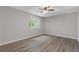 Bright bedroom featuring hardwood floors, a ceiling fan, and a sunlit window offering views of the outside at 2599 Willow Creek Dr, Duluth, GA 30096