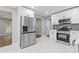 Modern kitchen with white cabinets, stainless steel appliances, and marble flooring at 2599 Willow Creek Dr, Duluth, GA 30096