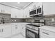 Close-up of updated kitchen showcasing stainless steel appliances, modern fixtures, and stylish backsplash at 2599 Willow Creek Dr, Duluth, GA 30096