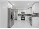Bright kitchen featuring white cabinetry, stainless steel appliances, and stylish backsplash at 2599 Willow Creek Dr, Duluth, GA 30096