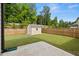The fenced backyard has a well-maintained lawn, a shed and green surroundings at 272 Broadstone Blvd, Acworth, GA 30101