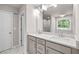 Luxurious bathroom featuring dual sinks, ample counter space, and a window to the tub-shower with marble accents at 272 Broadstone Blvd, Acworth, GA 30101