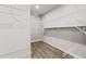 Practical walk-in closet equipped with white metal organizers and neutral paint over sleek hardwood floors at 272 Broadstone Blvd, Acworth, GA 30101