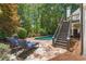Secluded backyard pool area with lounge chairs, stone patio, and stairway to deck at 414 Dogwood Way, Canton, GA 30114