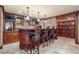 A custom bar area featuring a wooden bar, brick accents, shelving, and travertine tile flooring at 414 Dogwood Way, Canton, GA 30114