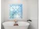 Modern bathroom featuring a stand-alone tub and ornate, frosted window at 414 Dogwood Way, Canton, GA 30114