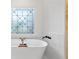 Serene bathroom with a freestanding tub, decorative window, and white subway tile backsplash at 414 Dogwood Way, Canton, GA 30114